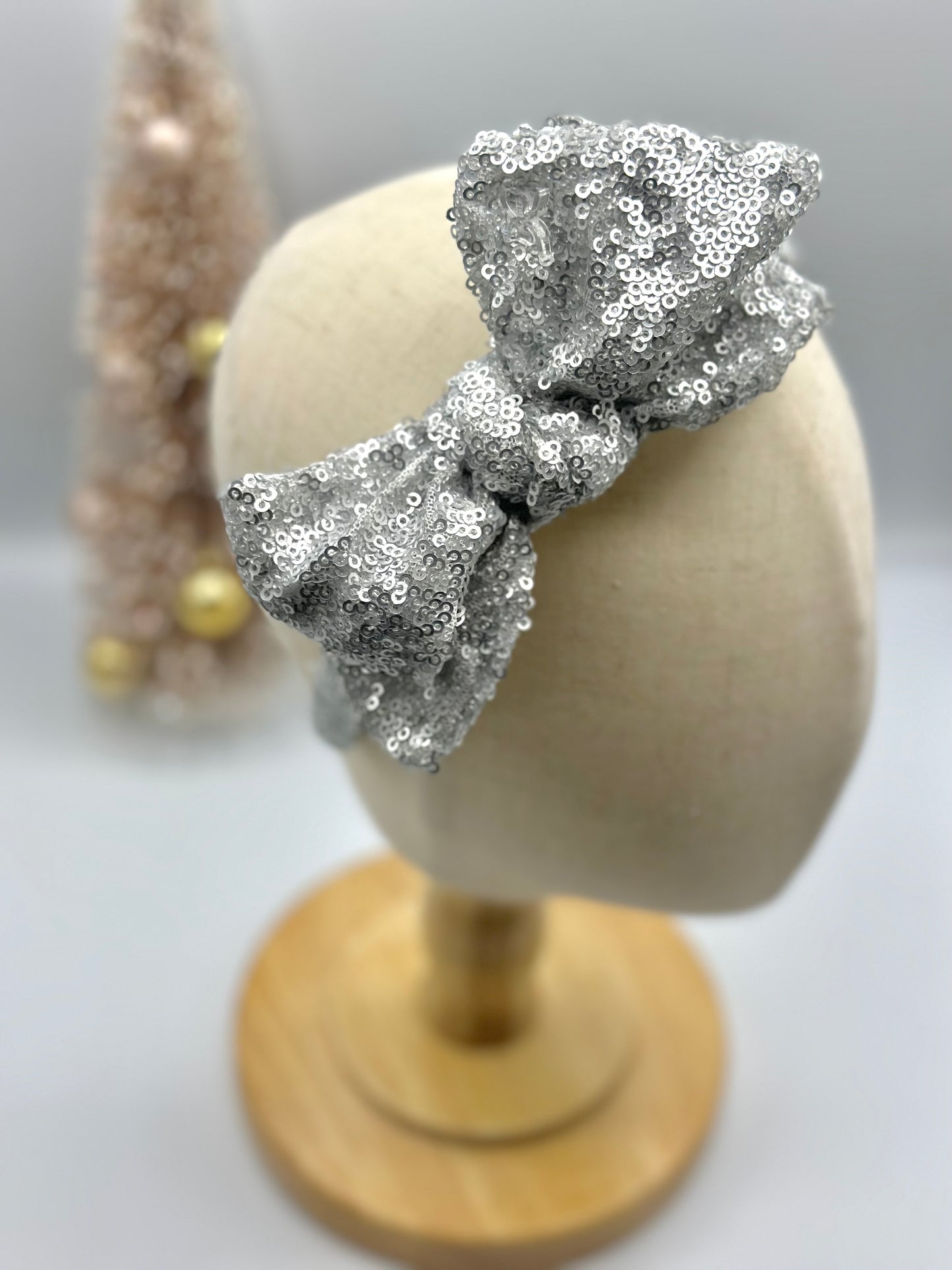 Hard headband with sequin bow.